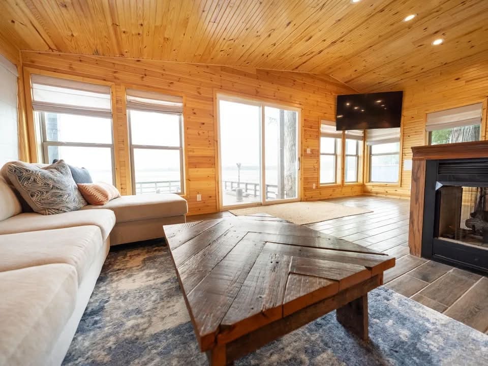 Lakeside Luxury Lodge great room with dining, living, and fireplace