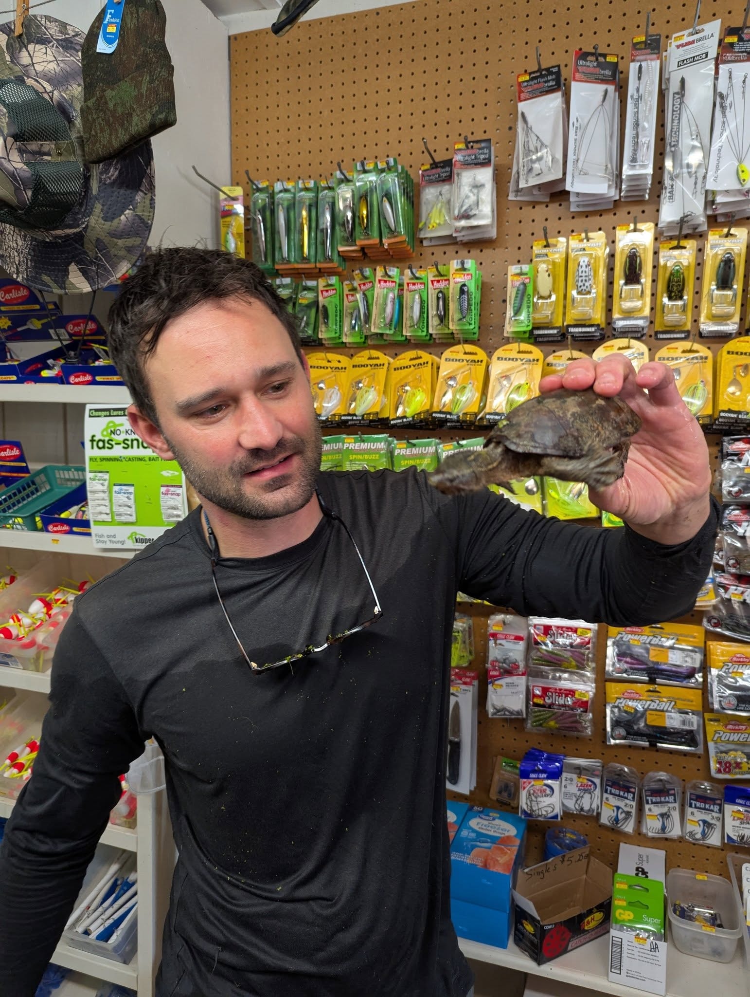 Staff member holding a small turtle inside the bait shop