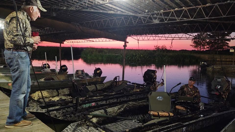 Hunters at the dock at pink sunrise preparing boats for the day
