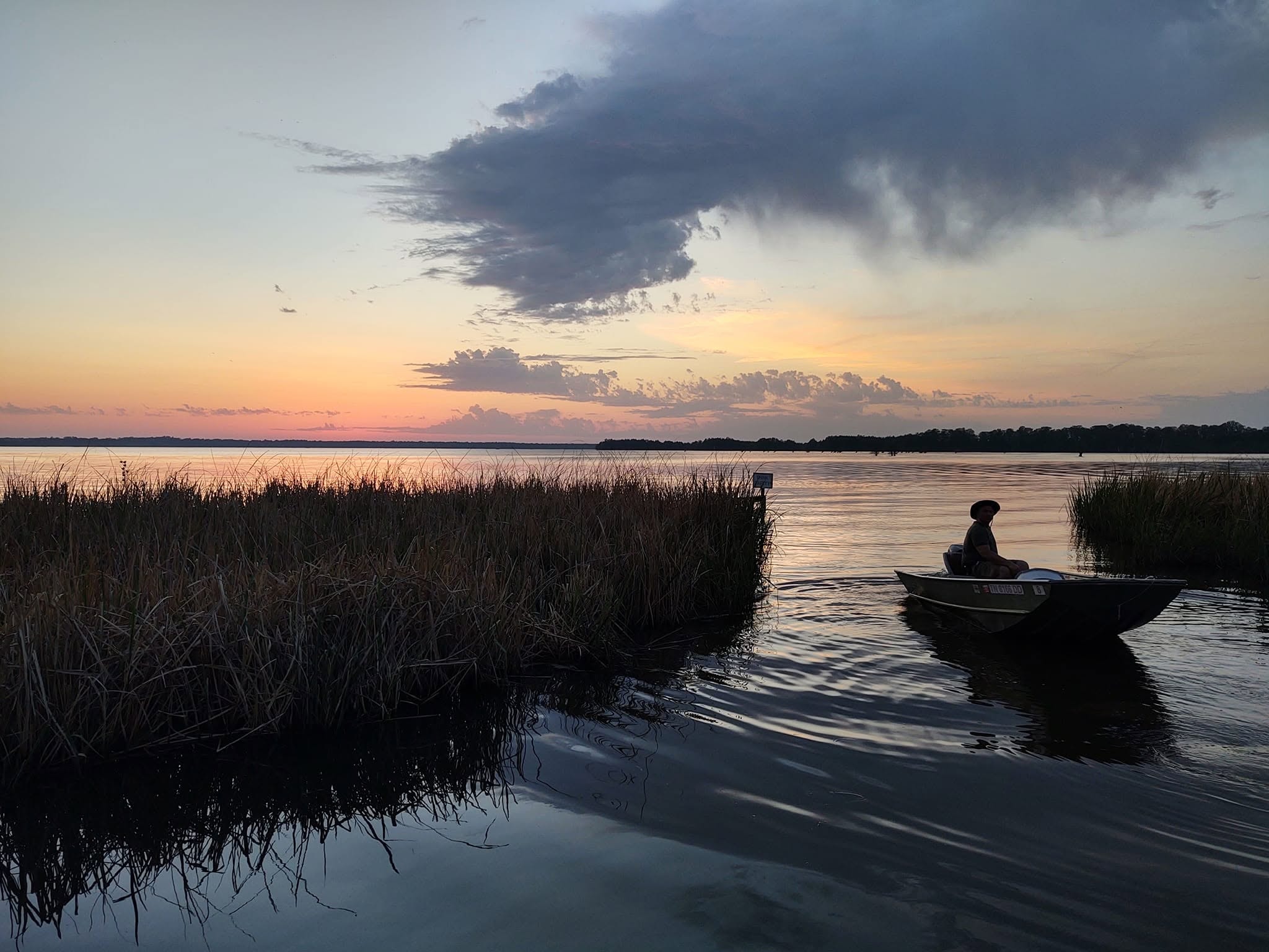 Fisherman in a jon boat at sunset on Reelfoot Lake