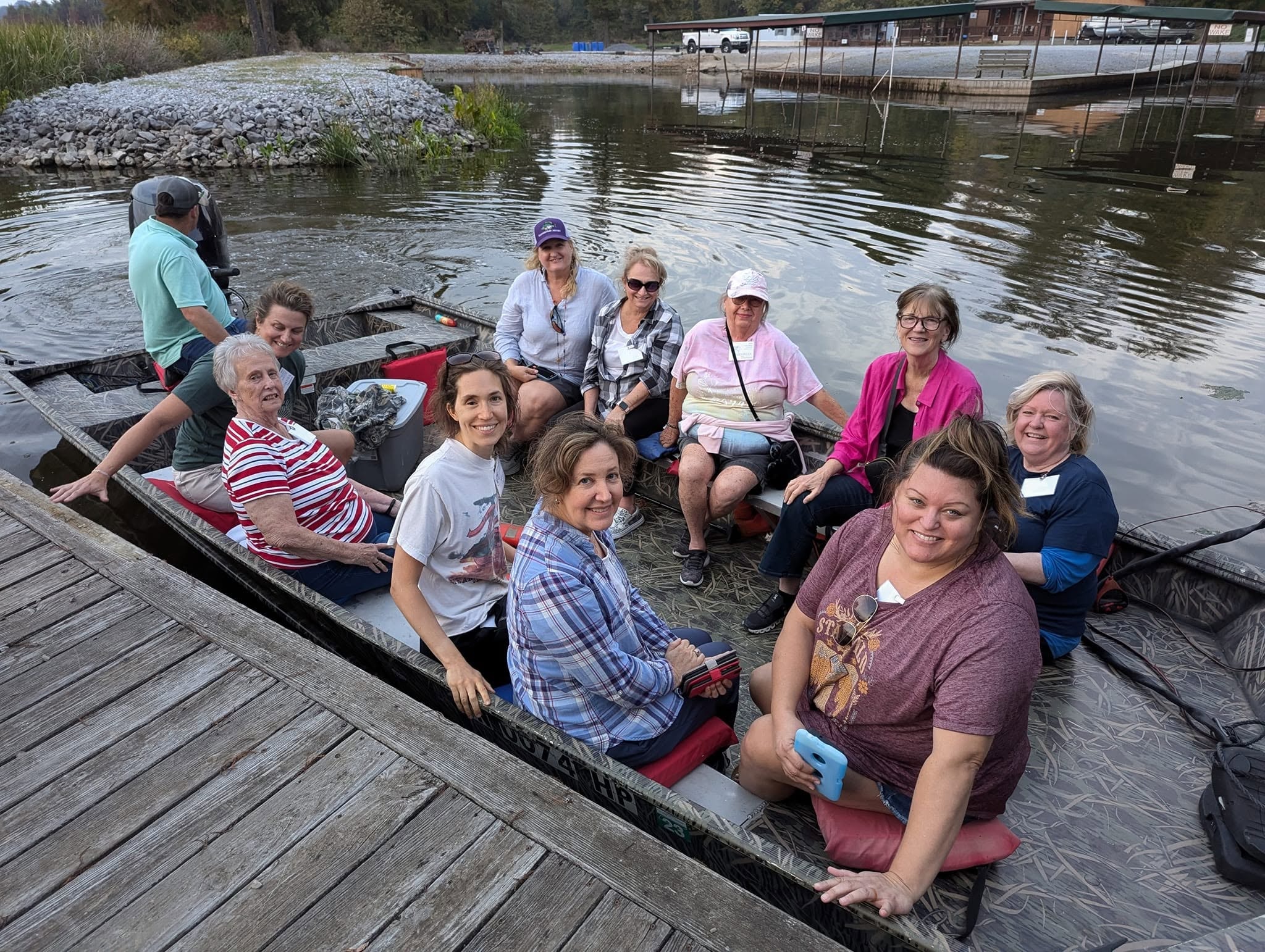 Group of women smiling in a jon boat at the Southshore Resort dock
