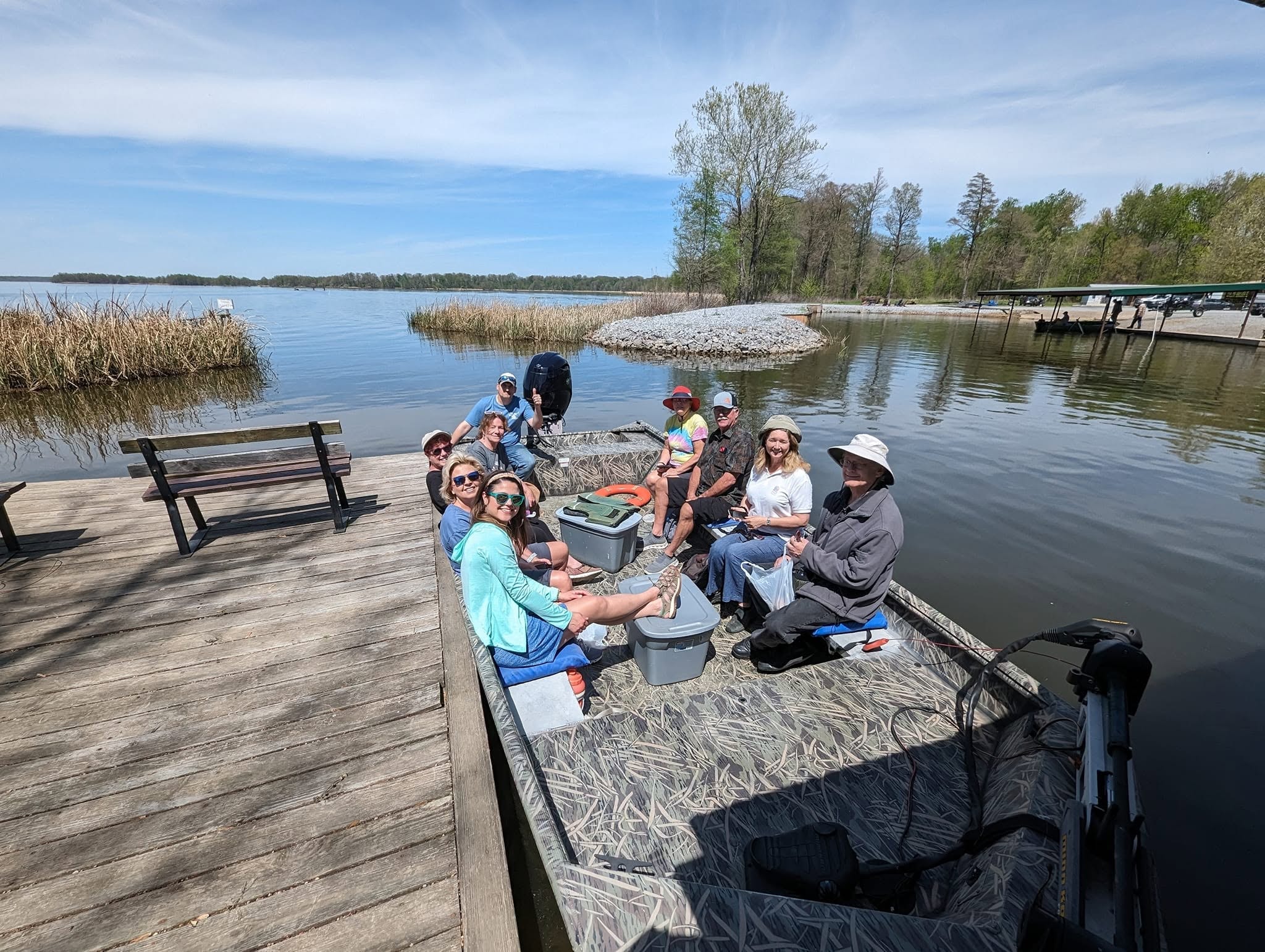 Tour group boarding a jon boat at the Southshore Resort dock on a sunny spring day