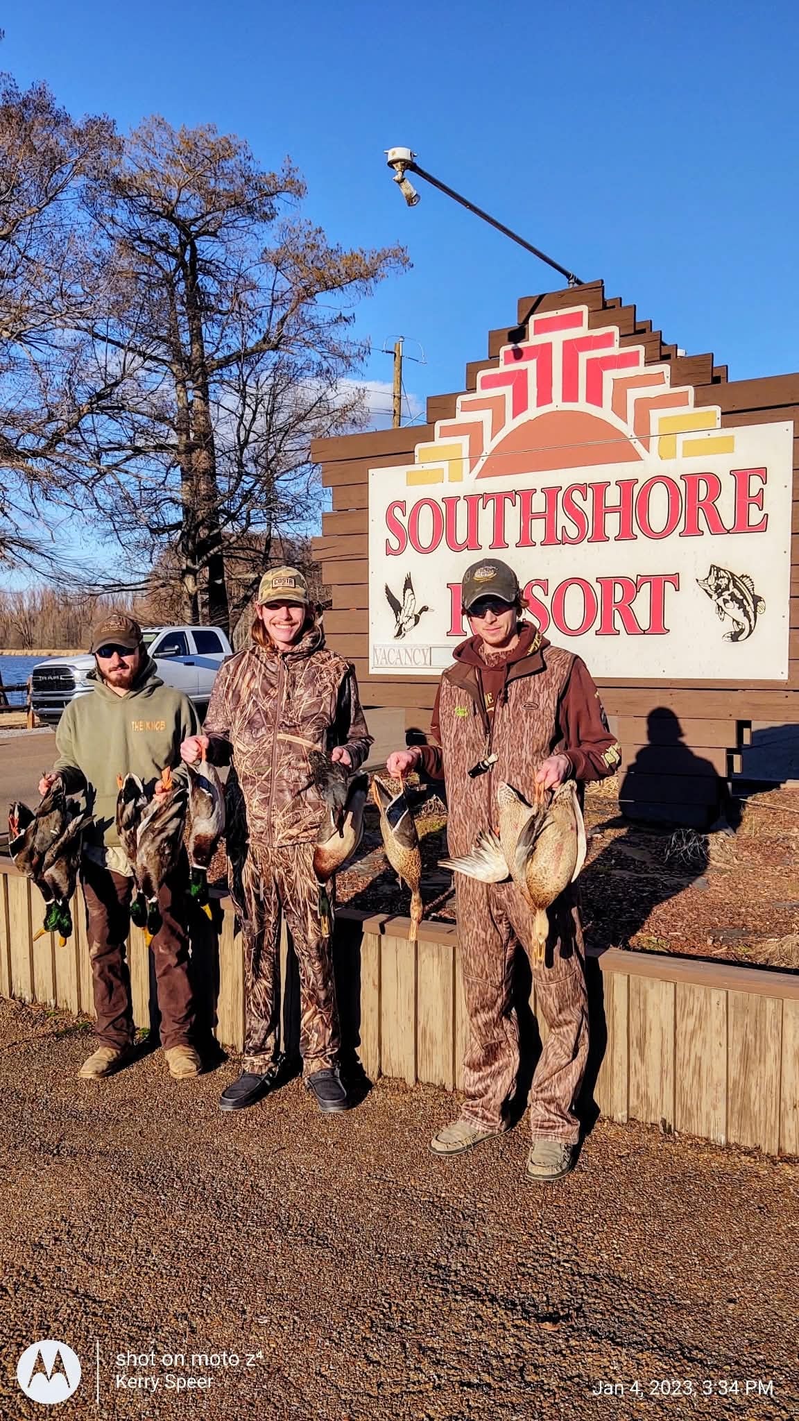 Group of hunters with large duck harvest and retriever