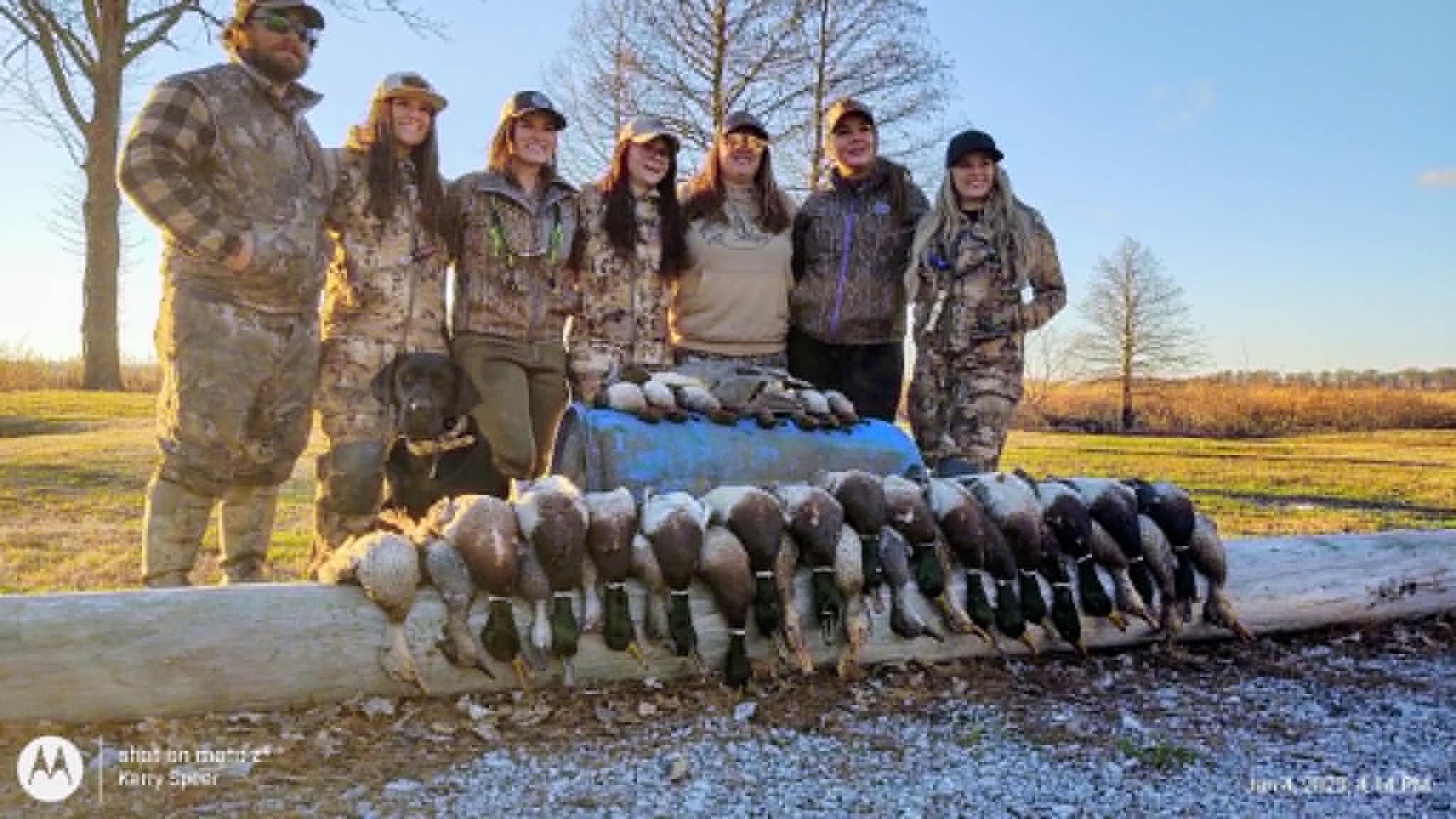 Three hunters displaying ducks at Southshore Resort sign