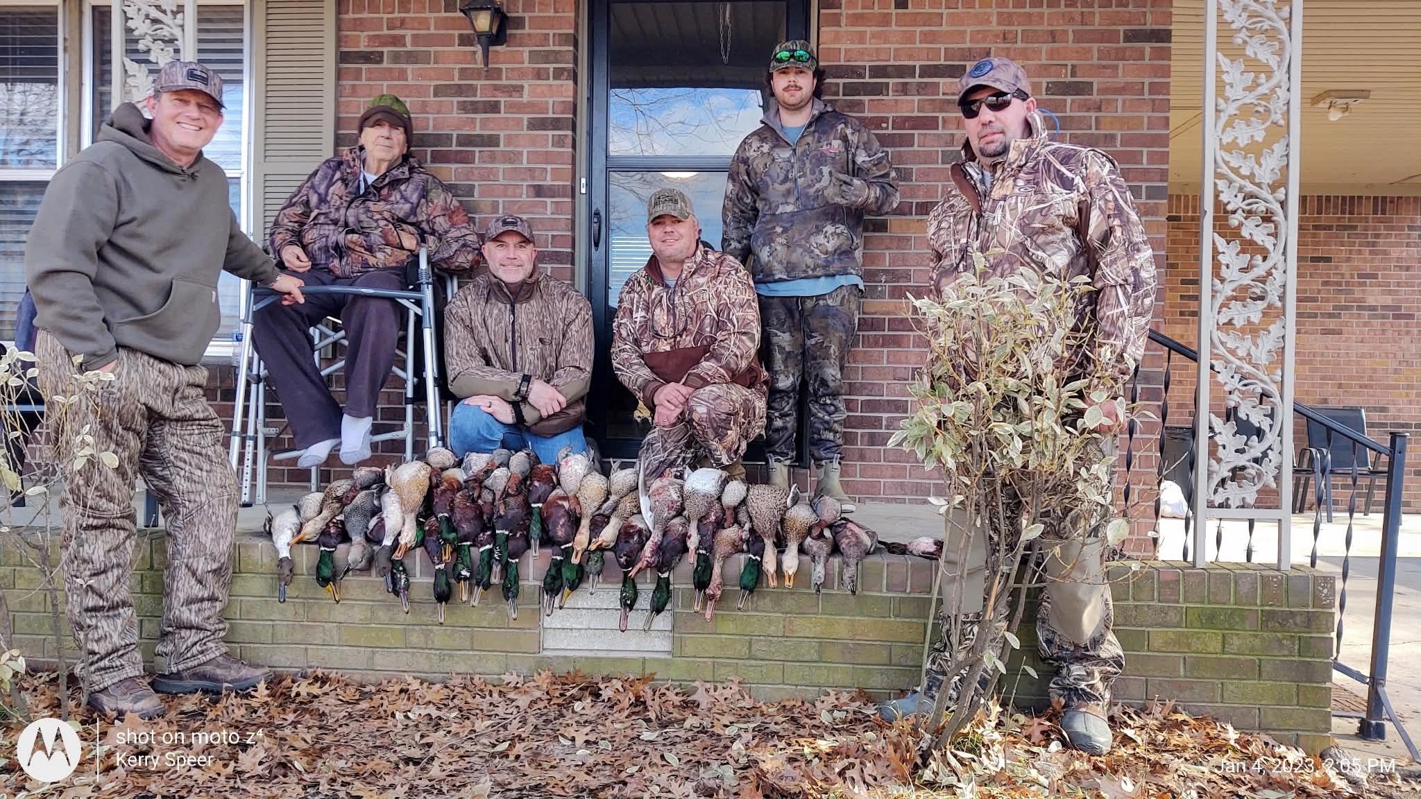 Hunting group posing with full duck limit on porch