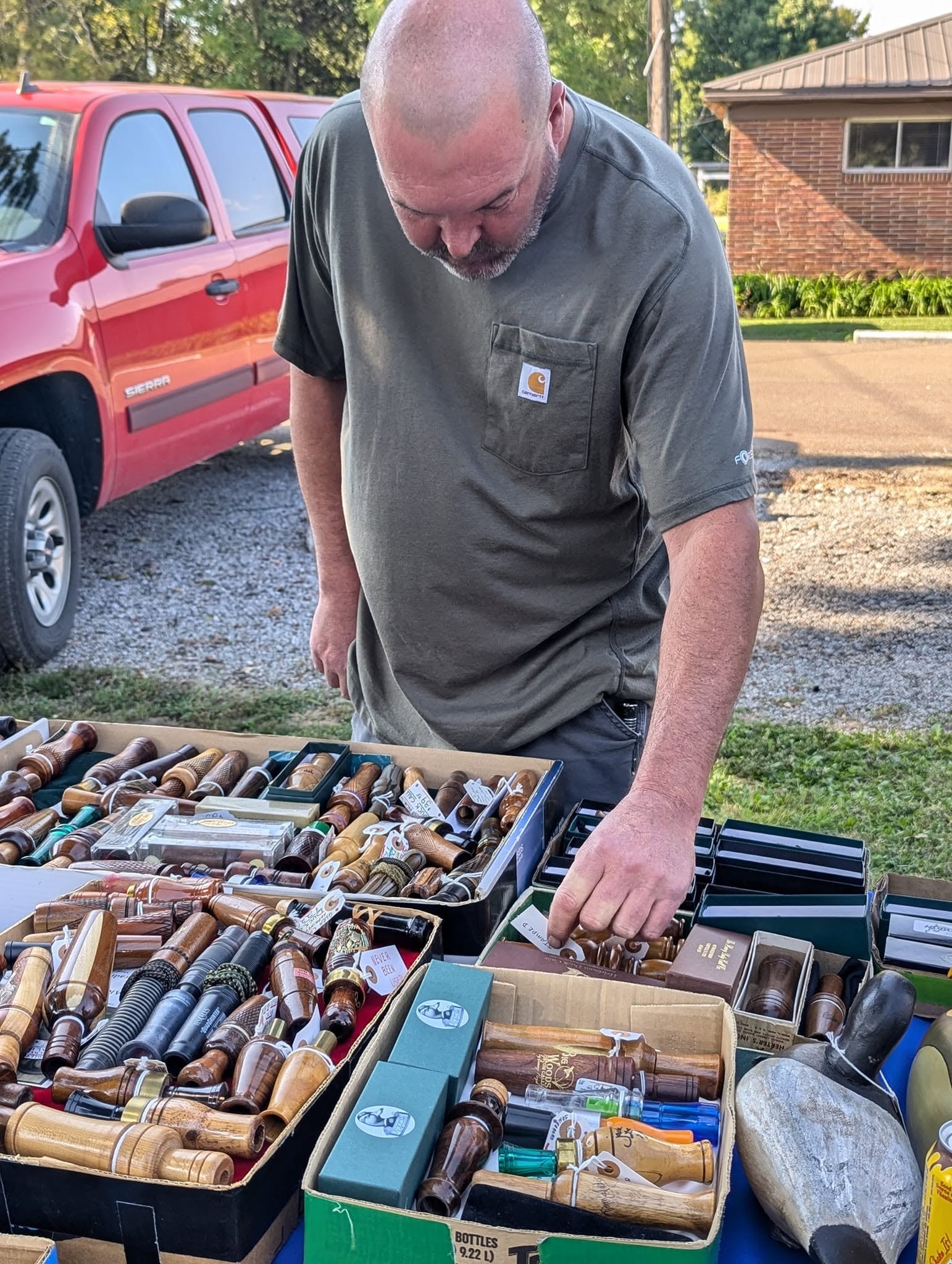 Man displaying wooden duck call collection