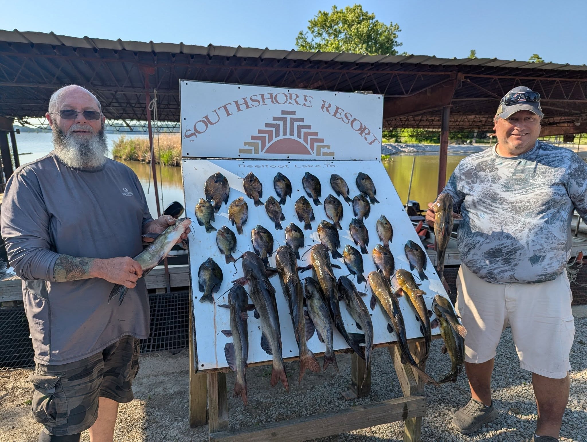 Two anglers with a mixed crappie and catfish board