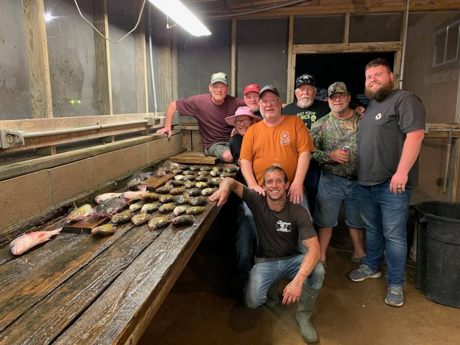 Large group at the fish cleaning station after a great day