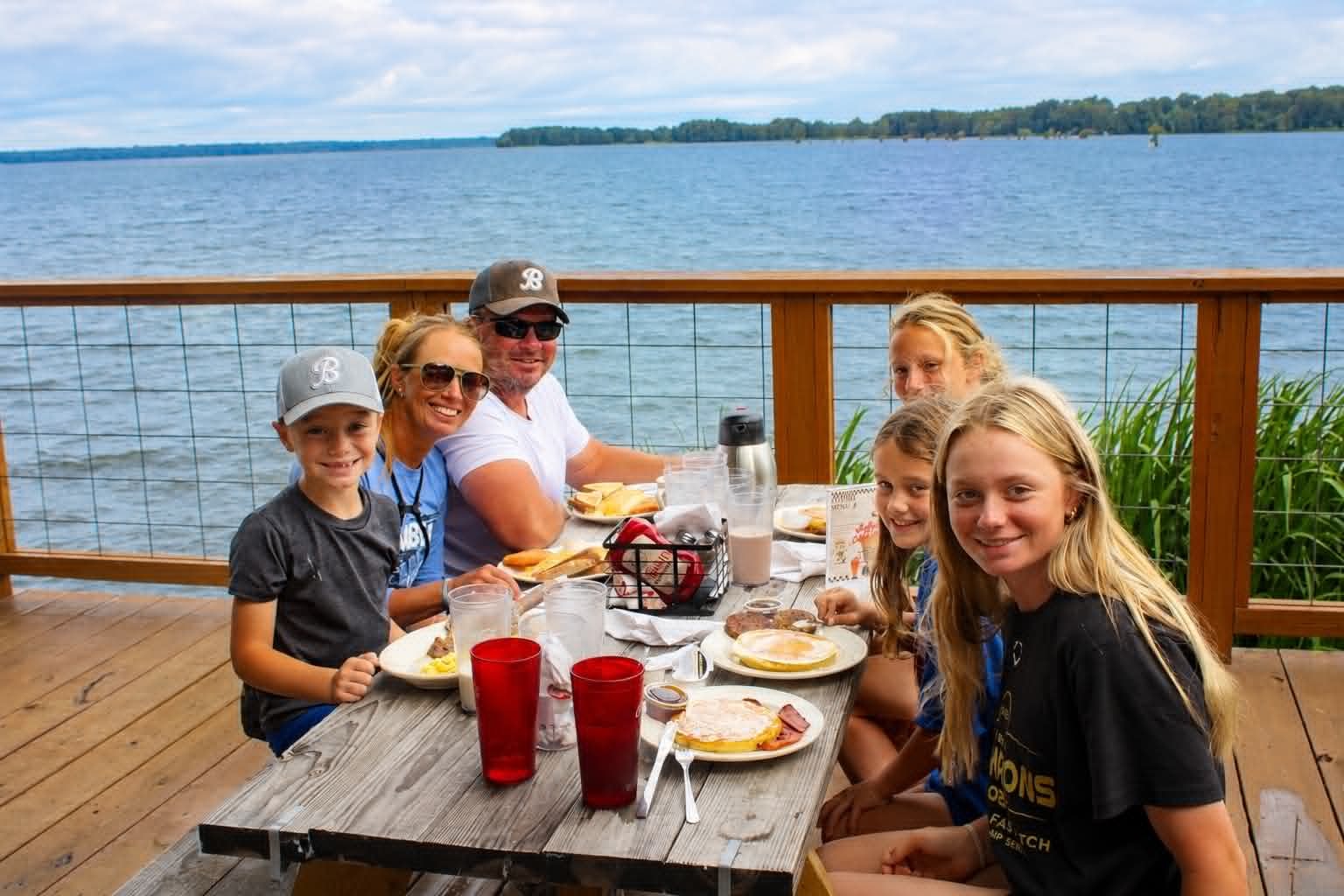 Family of six enjoying breakfast on the outdoor deck at The Boat House Restaurant with Reelfoot Lake views