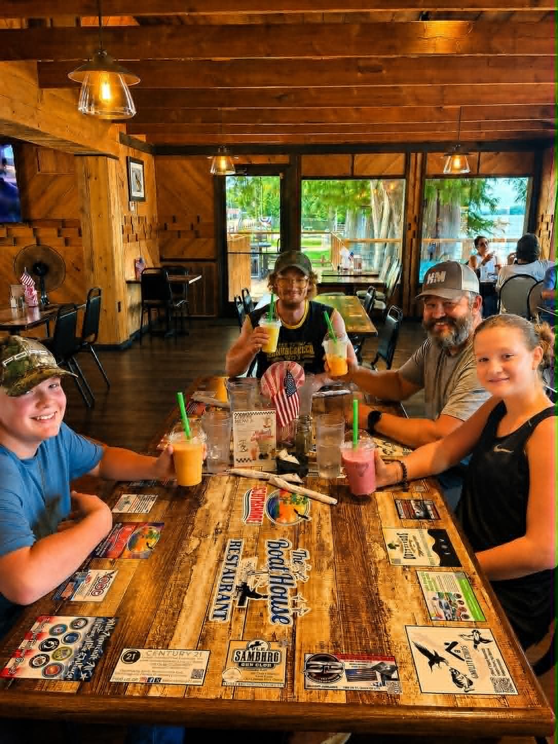 Family of four toasting with colorful milkshakes at The Boat House Restaurant