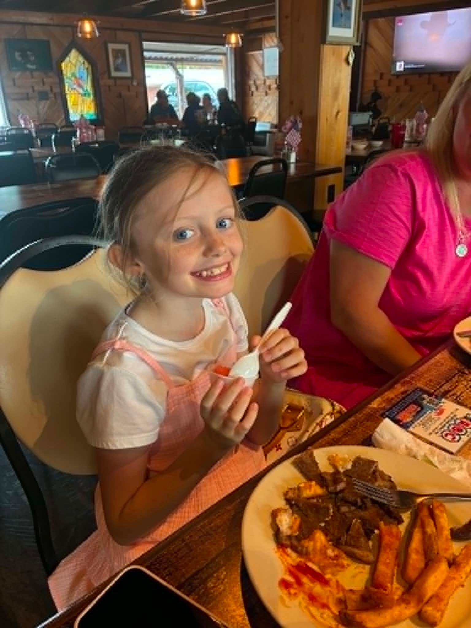 Young girl smiling with sherbet at The Boat House Restaurant wooden interior