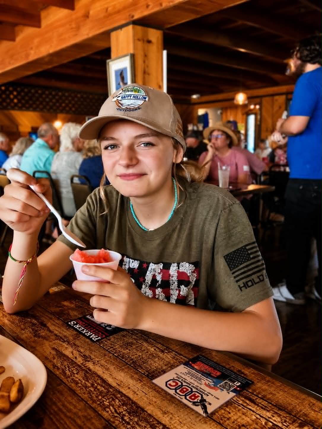 Teen girl enjoying sherbet at The Boat House Restaurant wearing a Happy Hollow Outdoors cap