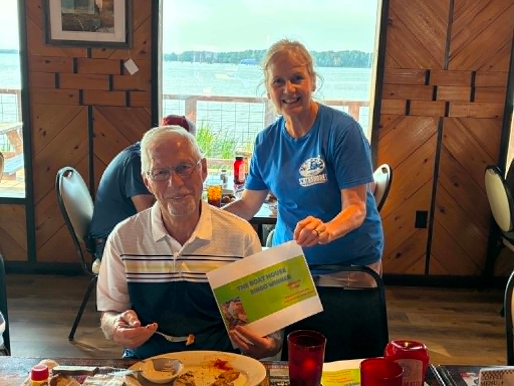 Boat House Bingo winner with staff member at The Boat House Restaurant
