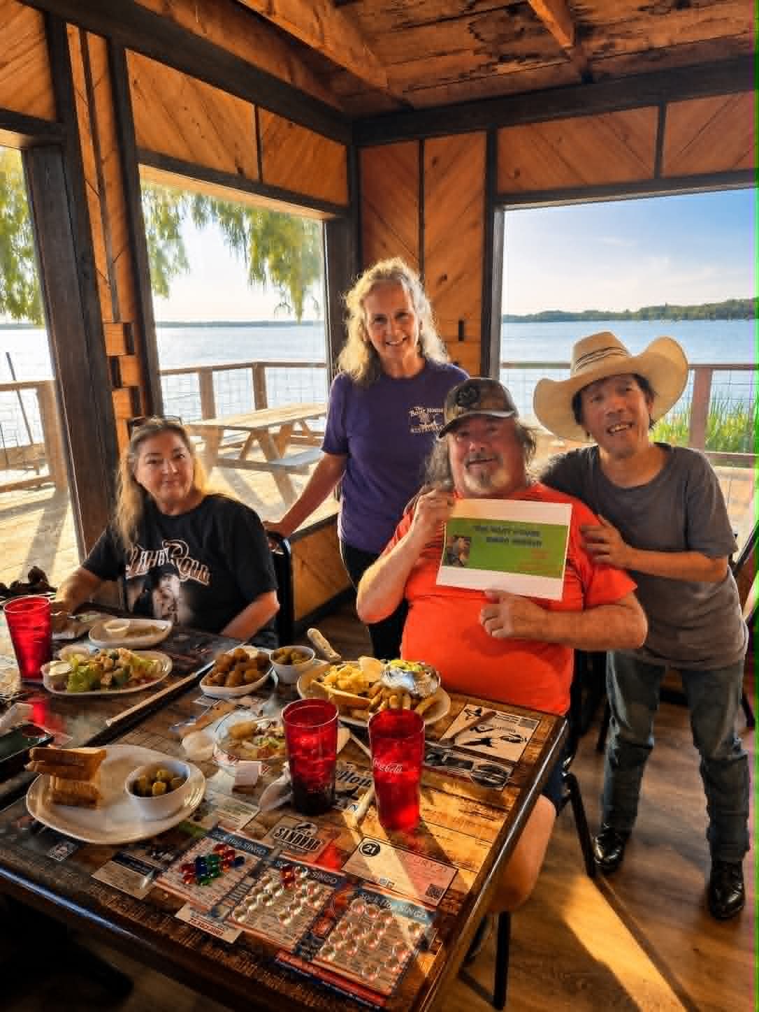 Group of friends celebrating Bingo night at The Boat House Restaurant with lake views
