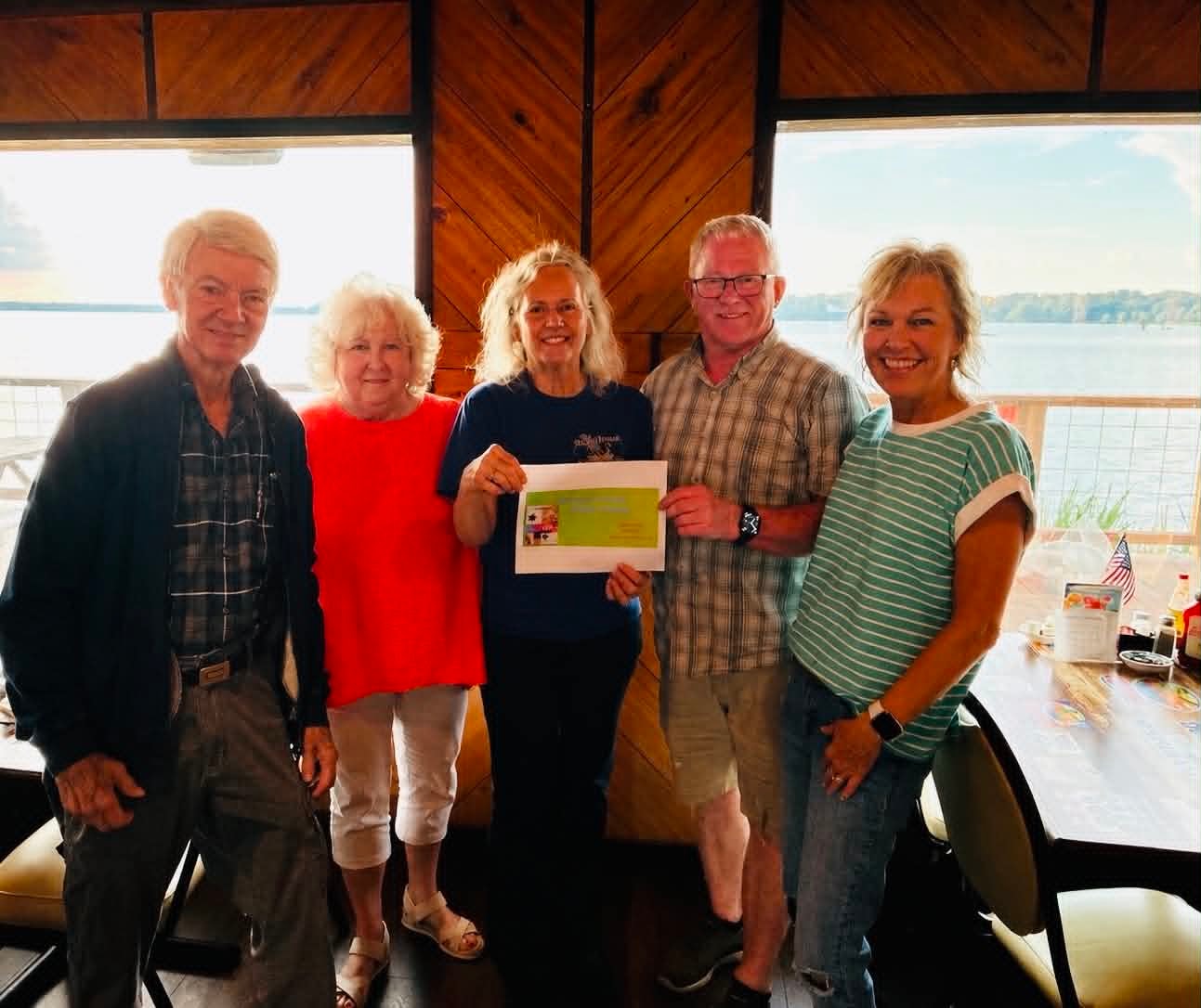 Five guests celebrating a Boat House Bingo win with certificate at Reelfoot Lake