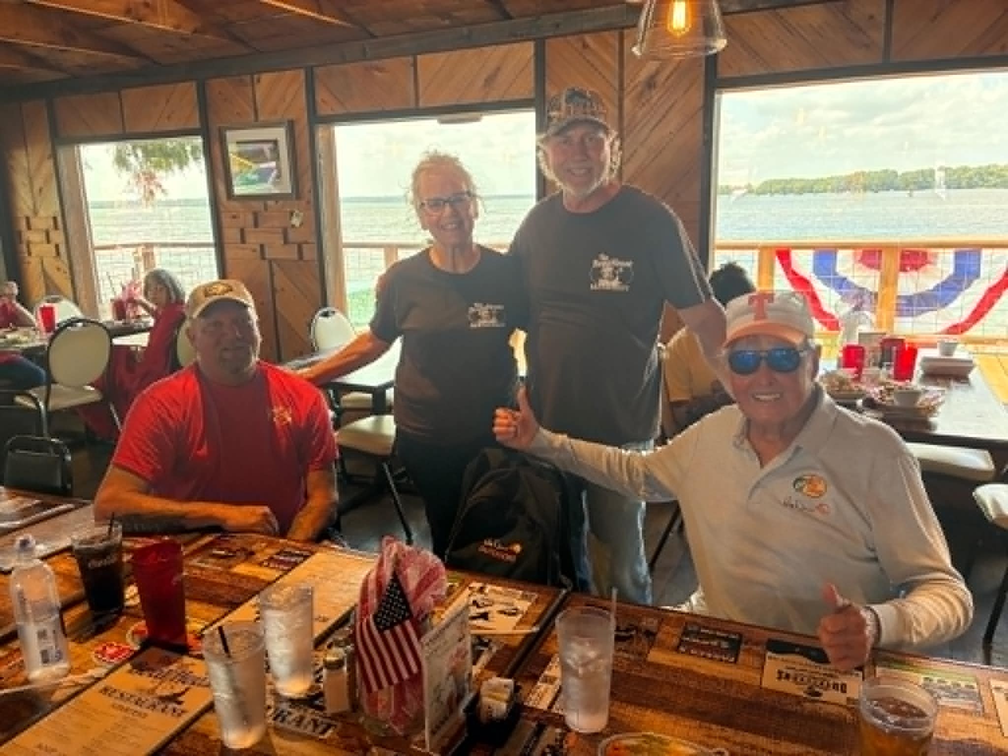 Staff and guests posing together at The Boat House Restaurant with lake views