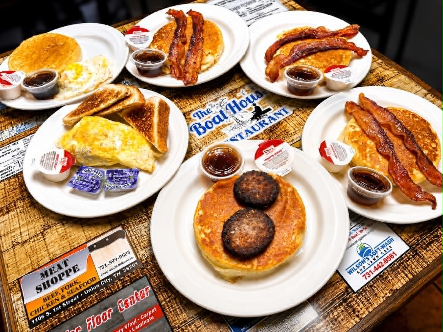 Full breakfast spread at The Boat House Restaurant — pancakes, omelets, bacon and sausage