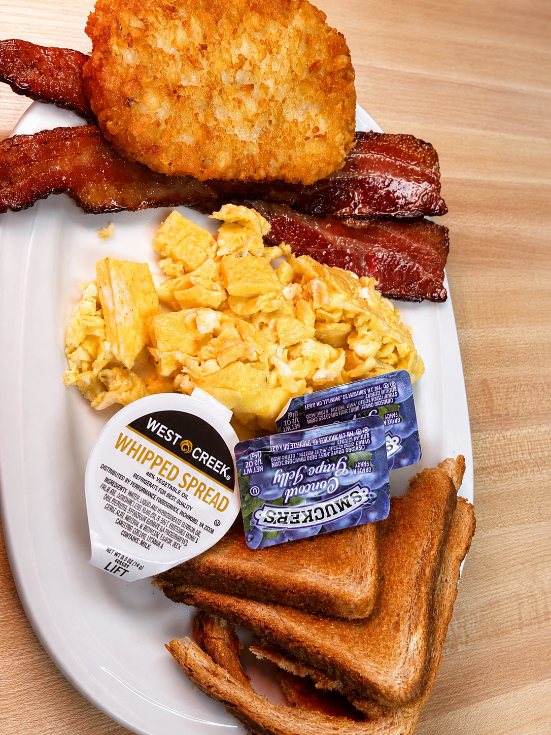 Country breakfast with scrambled eggs, bacon, hash browns and toast
