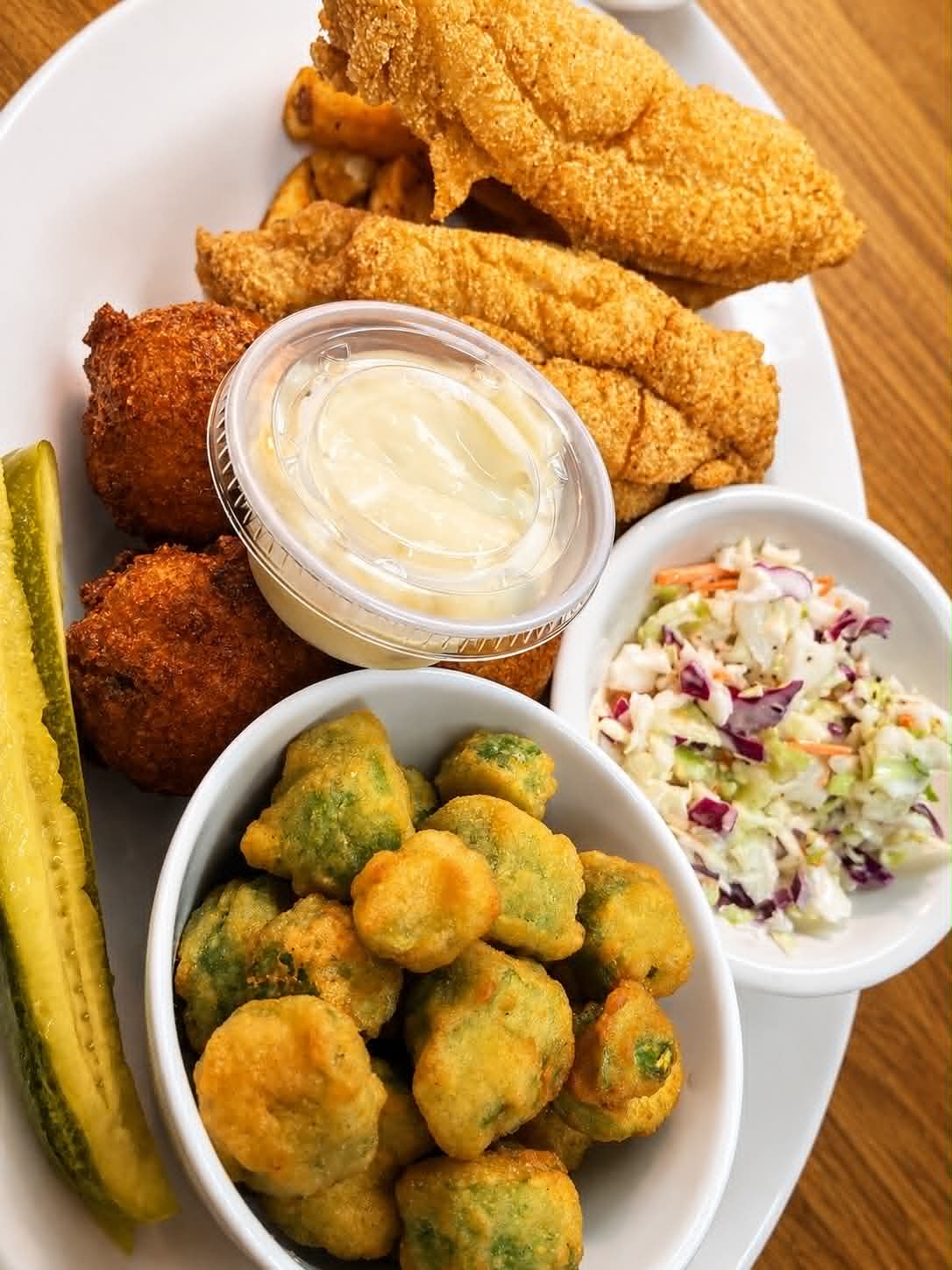 Fried catfish fillets with hush puppies, fried okra, coleslaw and pickles at The Boat House Restaurant