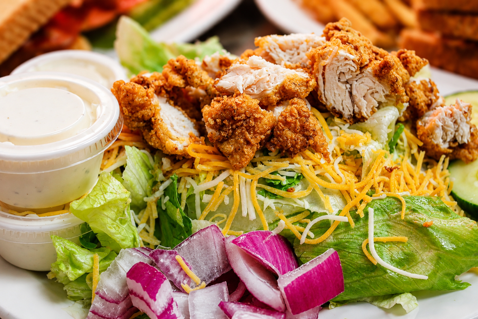 Crispy fried chicken salad with shredded cheese and ranch at The Boat House Restaurant