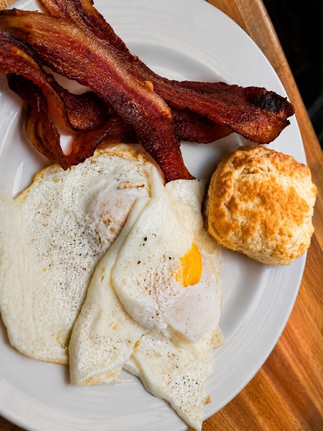 Fried eggs with crispy bacon and a golden biscuit at The Boat House Restaurant