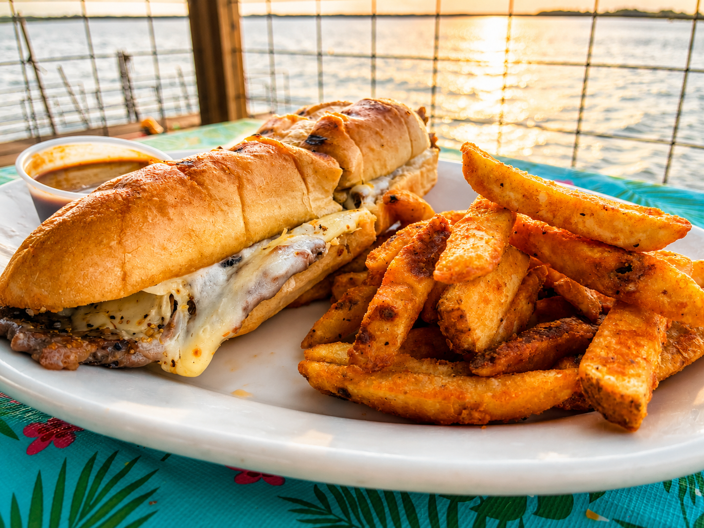 Philly cheesesteak sub with fries overlooking Reelfoot Lake at sunset