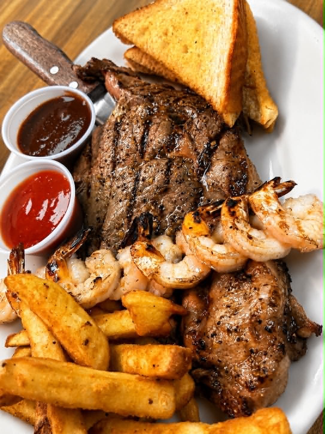 Grilled steak and shrimp with seasoned fries and toast at The Boat House Restaurant