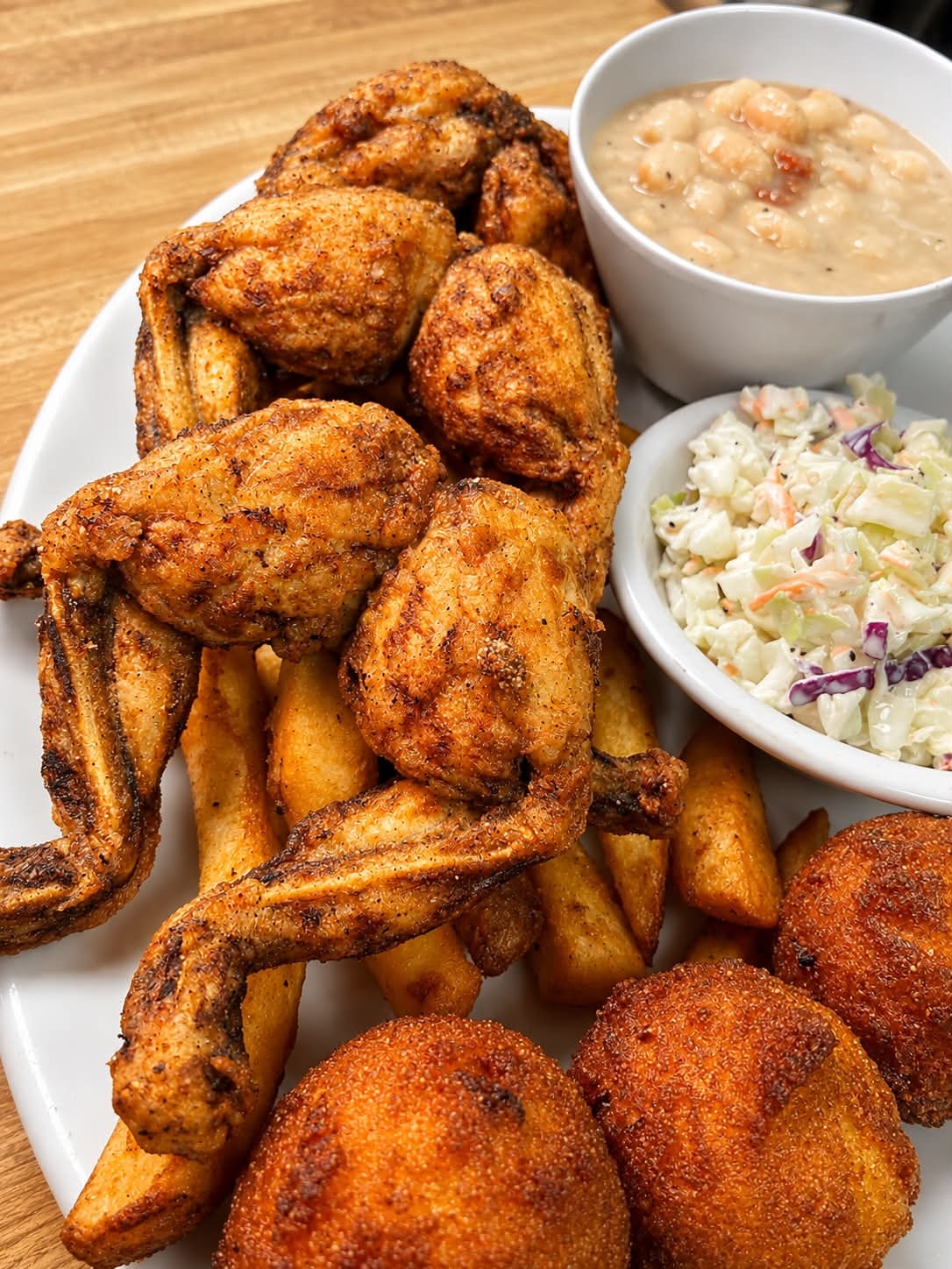 Seasoned fried chicken wings with steak fries, coleslaw and white beans at The Boat House Restaurant