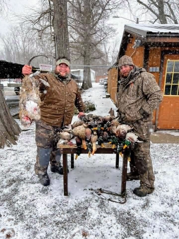 Hunters displaying game catch in snow