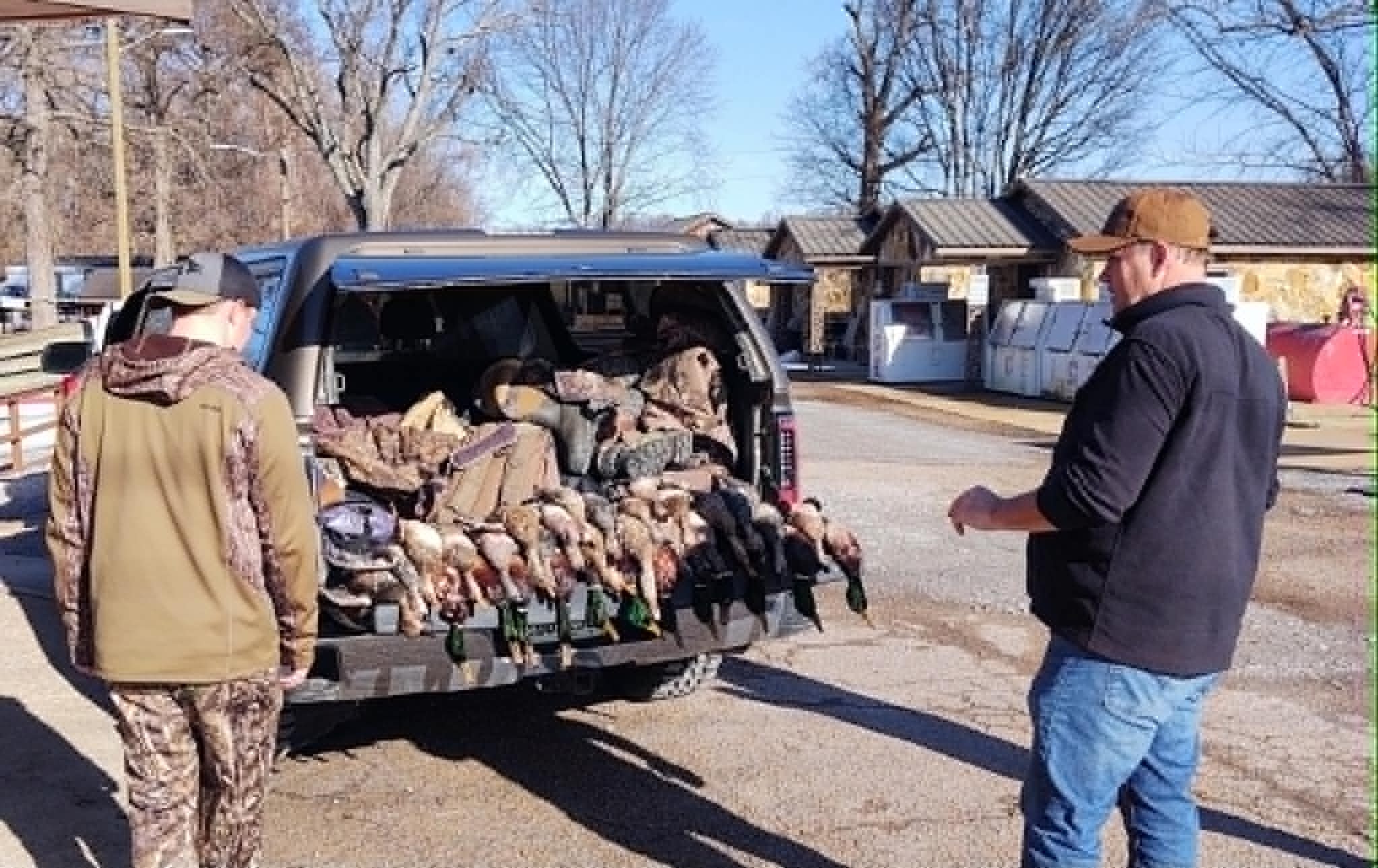 Hunters displaying game birds in truck bed