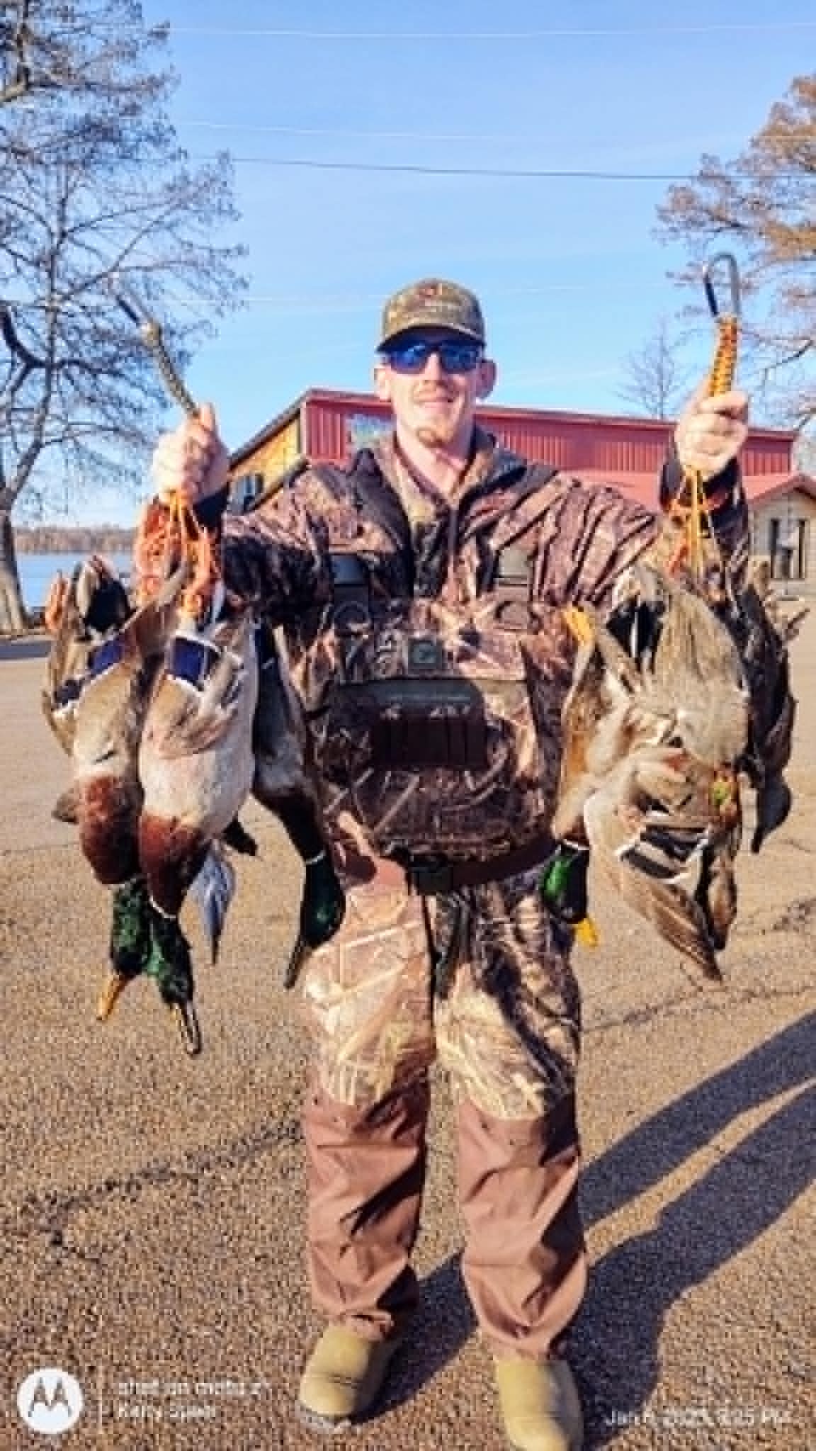 Hunter holding caught ducks outdoors